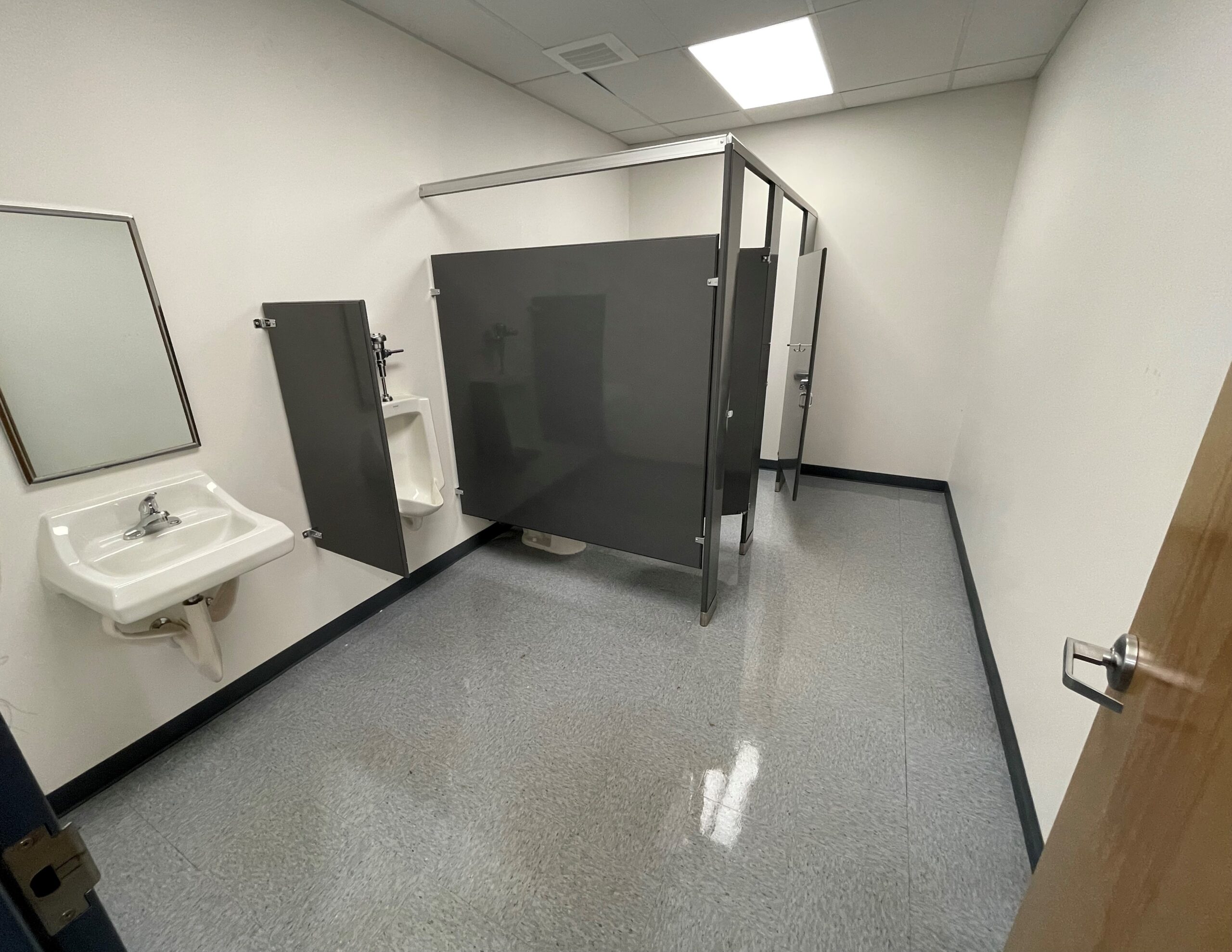 A bathroom featuring a sink and toilet, with neutral-colored walls and tiled flooring.